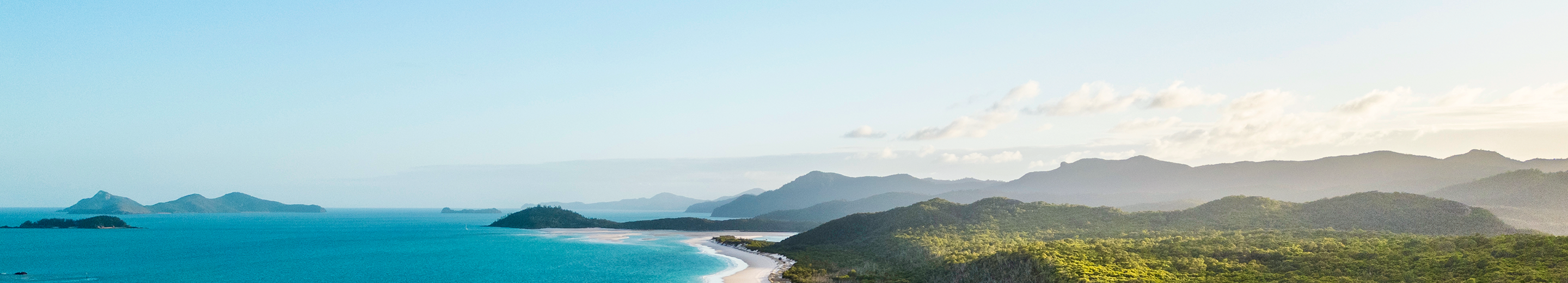 An aerial view of an island with white sand beaches and turquoise waters.