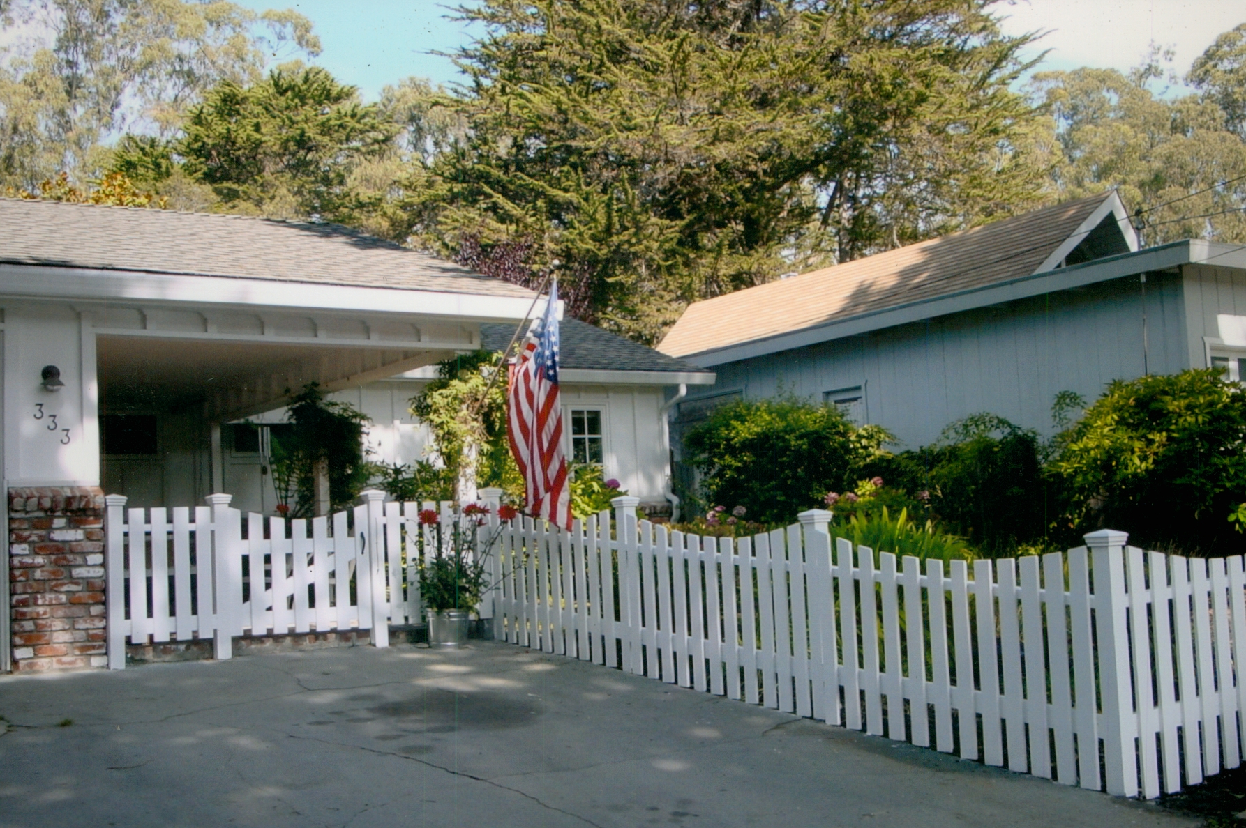 White picket fence surrounding a home, enhancing curb appeal with a classic residential fencing style.