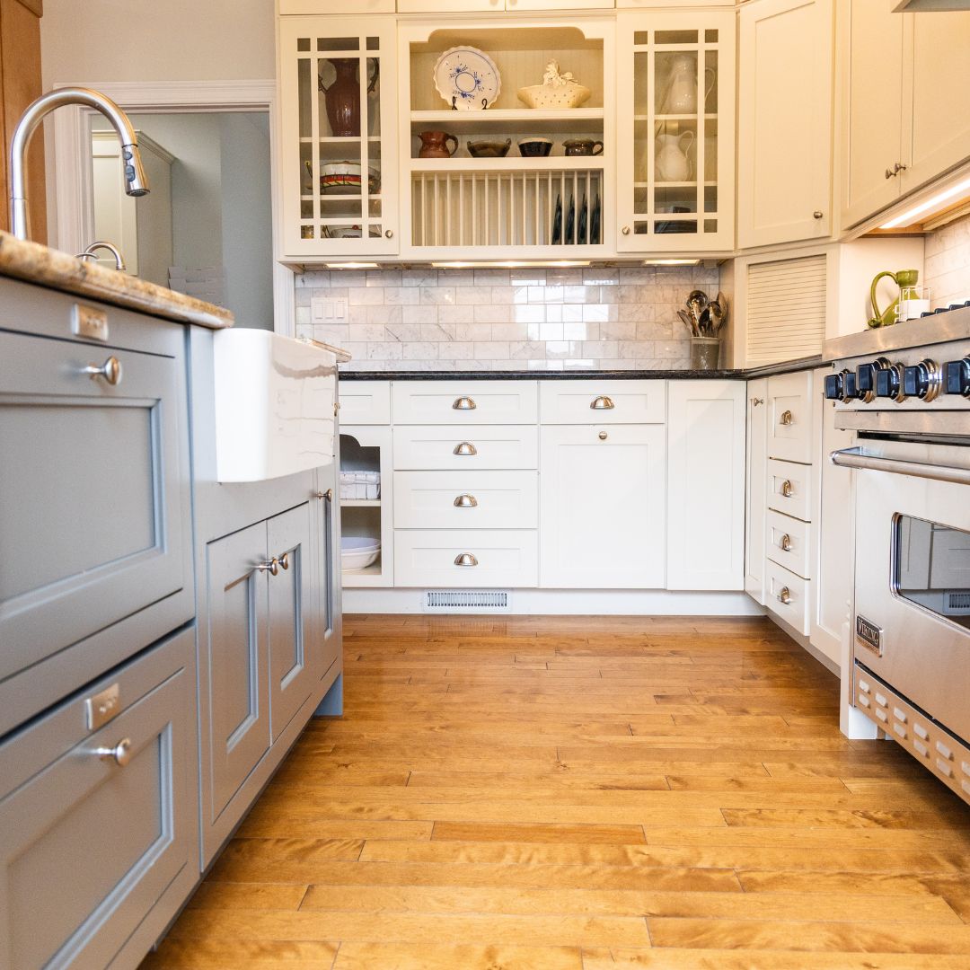 Elegant base cabinets with two-tone painted finish and apron-front sink in a classic kitchen remodel.