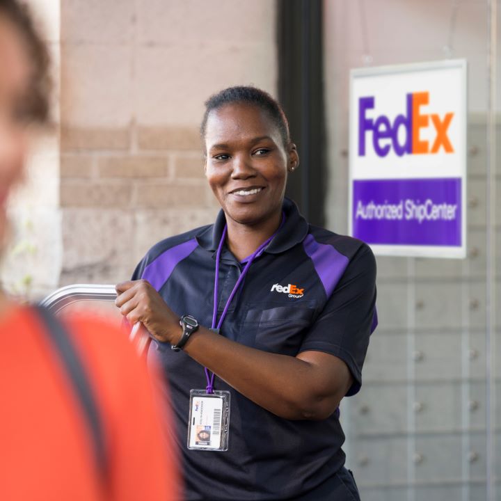 FedEx courier standing outside FedEx Authorized Ship Center FedEx Authorized ShipCenter Fort Walton Beach (251)753-8221
