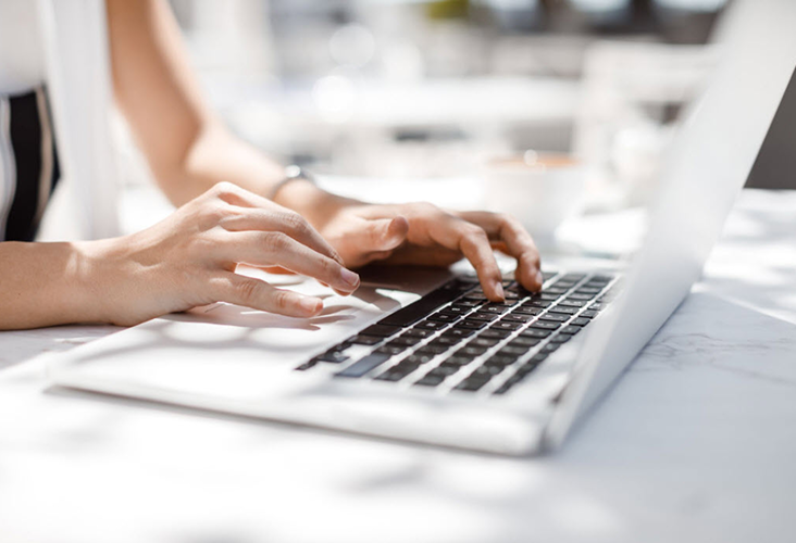 Closeup of a person typing on their laptop.