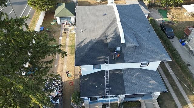 Drone photograph displaying a newly completed residential roofing project. Fresh shingles provide im 