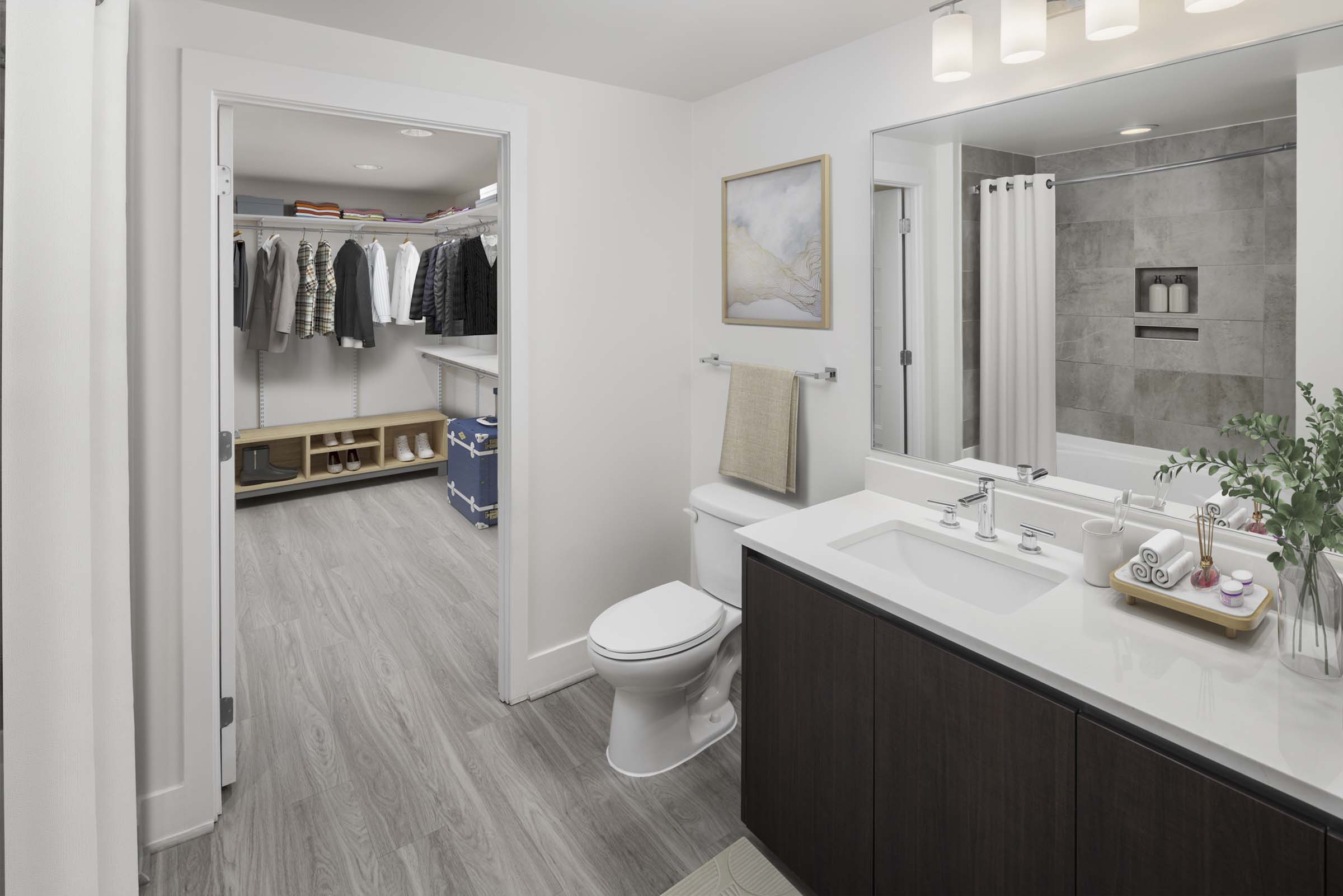 Contemporary style bathroom with quartz countertops and access to a spacious walk-in closet at Camden NoMa Apartments in Washington, DC.