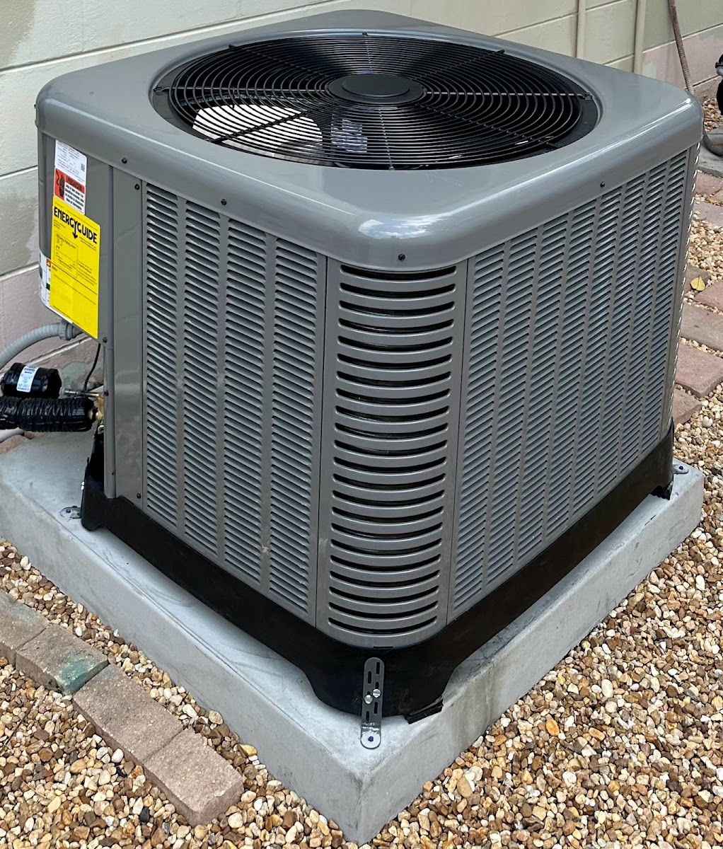 Residential outdoor AC condenser installed on a gravel pad to provide efficient and consistent home cooling.