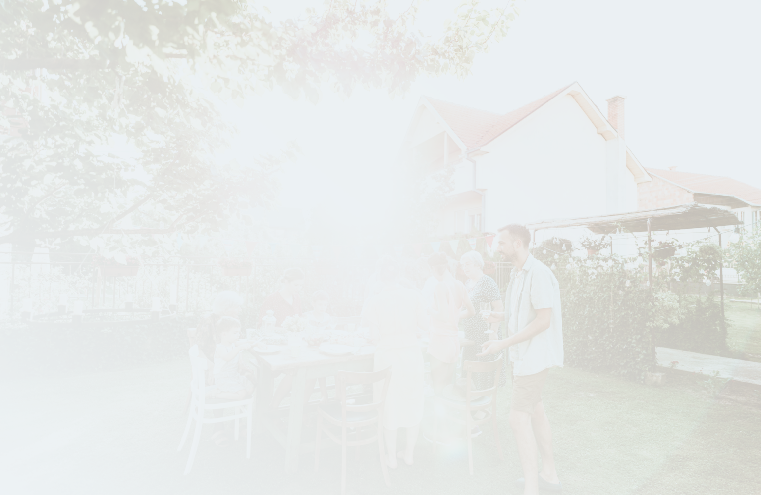 A multigenerational family sharing a meal in their backyard.