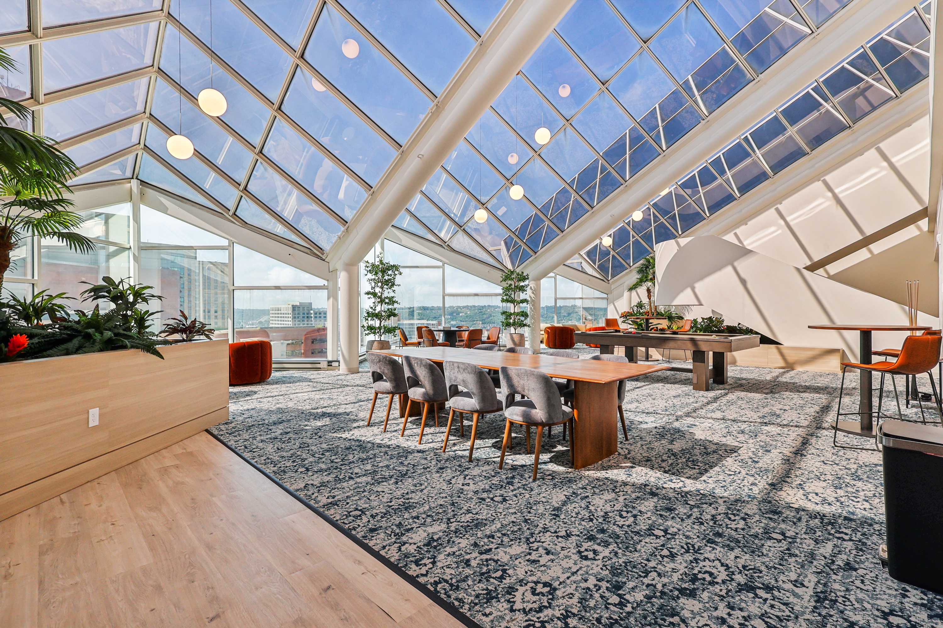 A modern dining area with a glass ceiling and wooden furniture