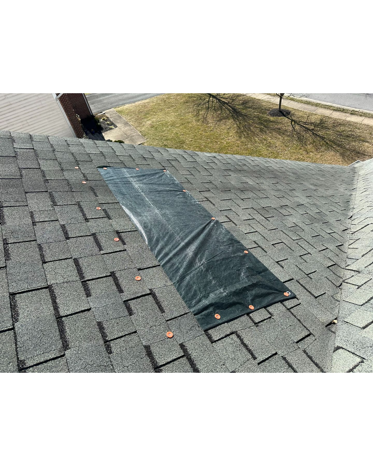 Tarp installed to stop water from getting under the shingles and into the house