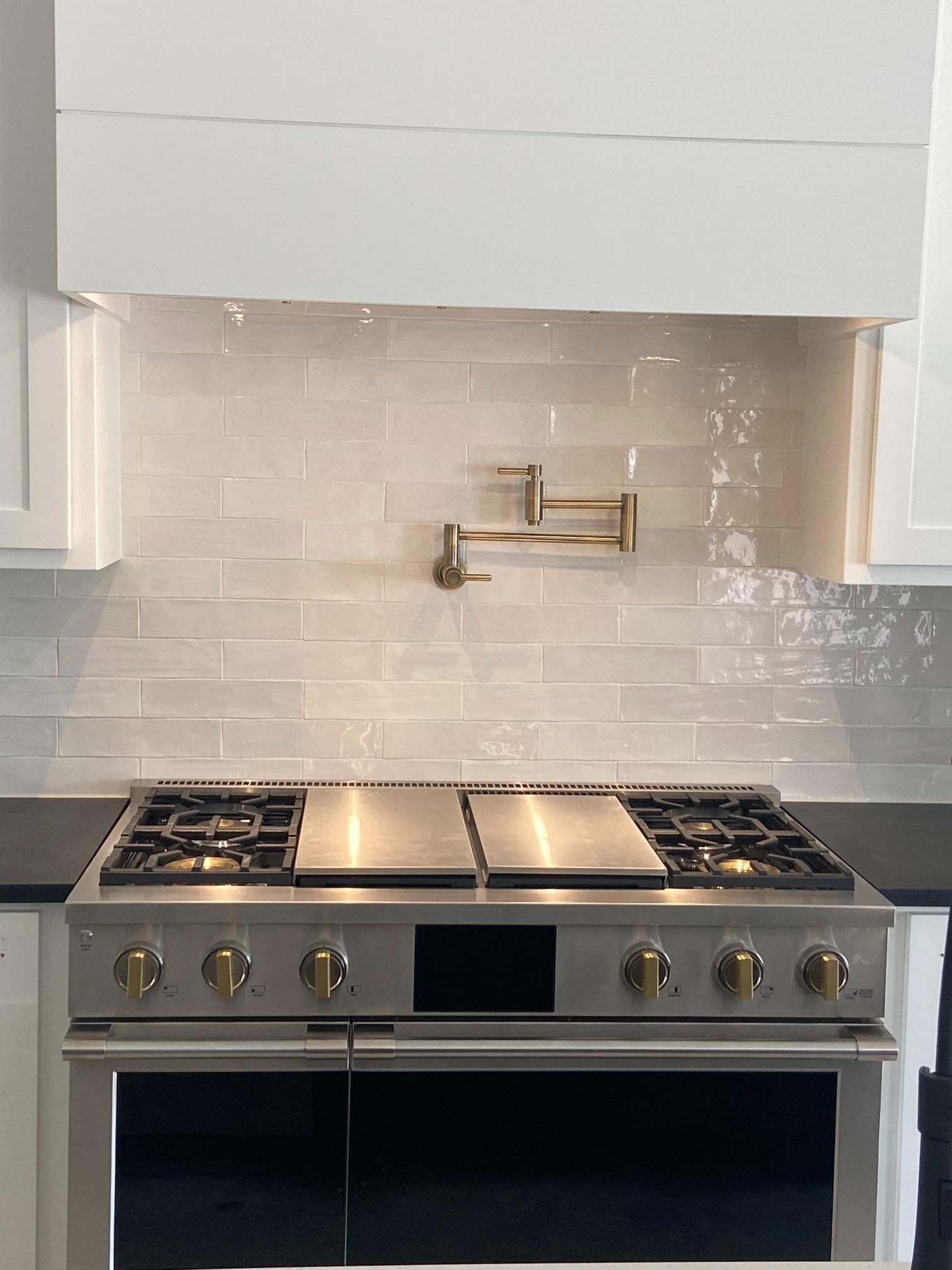 Kitchen remodeling project featuring a professional stainless steel range, multiple burners, dual gr 