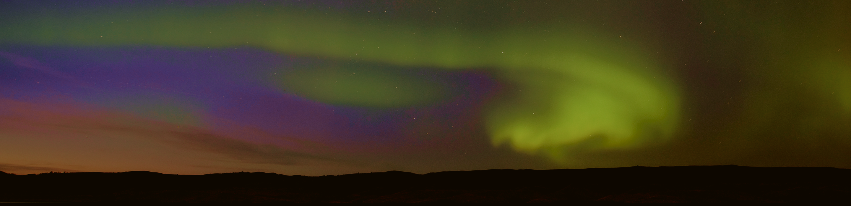 A curtain of green northern lights lighting up the sky.