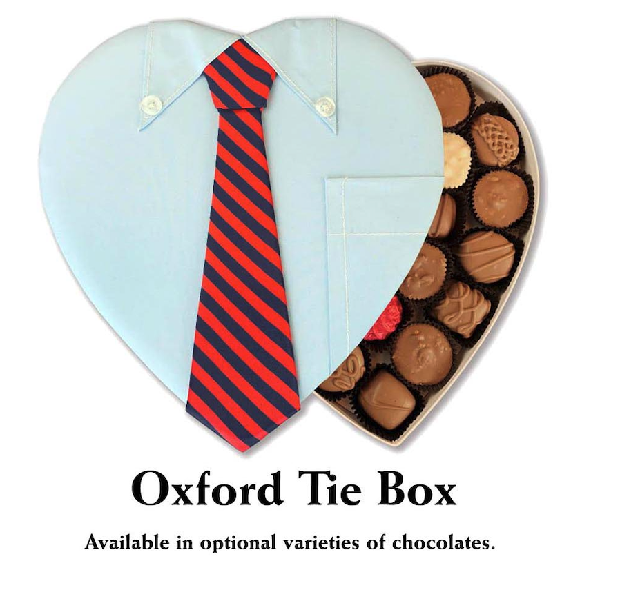 A refined 24-piece chocolate box from Florence’s Exquisite Chocolates in Rexburg, ID, tailored for a distinguished Valentine’s Day gift. The "Oxford Tie Box" features a creative heart-shaped lid designed to resemble a classic light blue dress shirt with a red and navy striped tie, adding a touch of sophistication. Inside, a premium selection of handcrafted chocolates, including milk chocolate, dark chocolate, and caramel varieties, awaits. This elegant packaging makes it a perfect gift for those who appreciate both fine chocolates and stylish presentation.