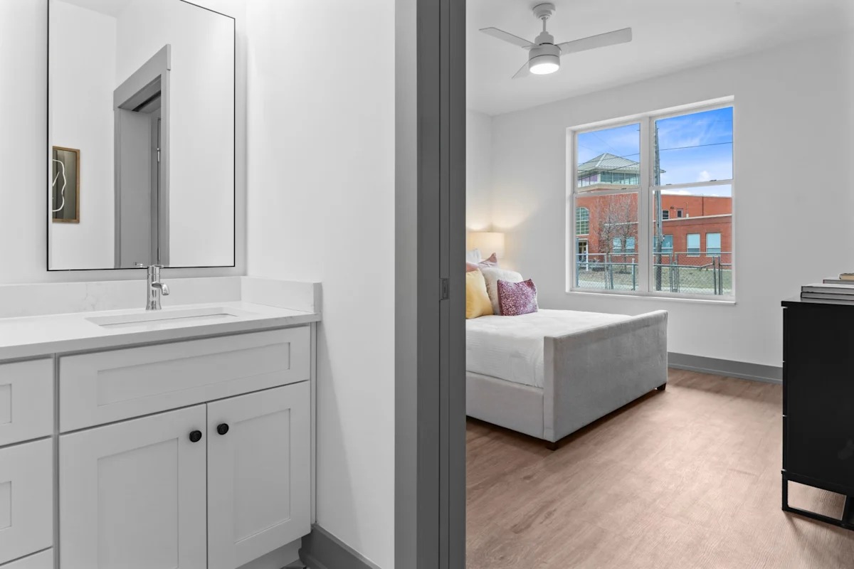 A bathroom with a white sink and a large mirror. 