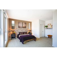 Spacious bedroom with textured stone accent wall