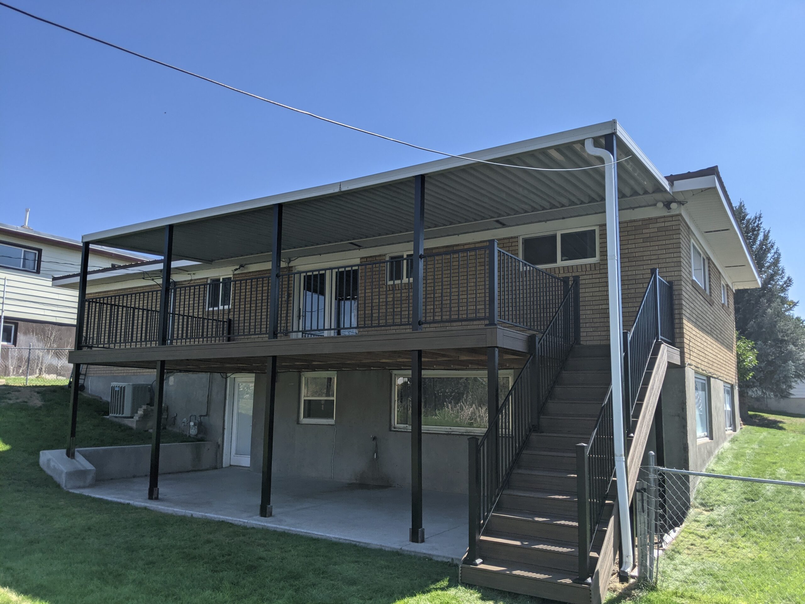 Maximize your outdoor living with a custom second-story deck from DeckPro LLC. This project features durable composite decking, sleek metal railing, and a full roof cover that provides a dry, shaded patio space underneath.