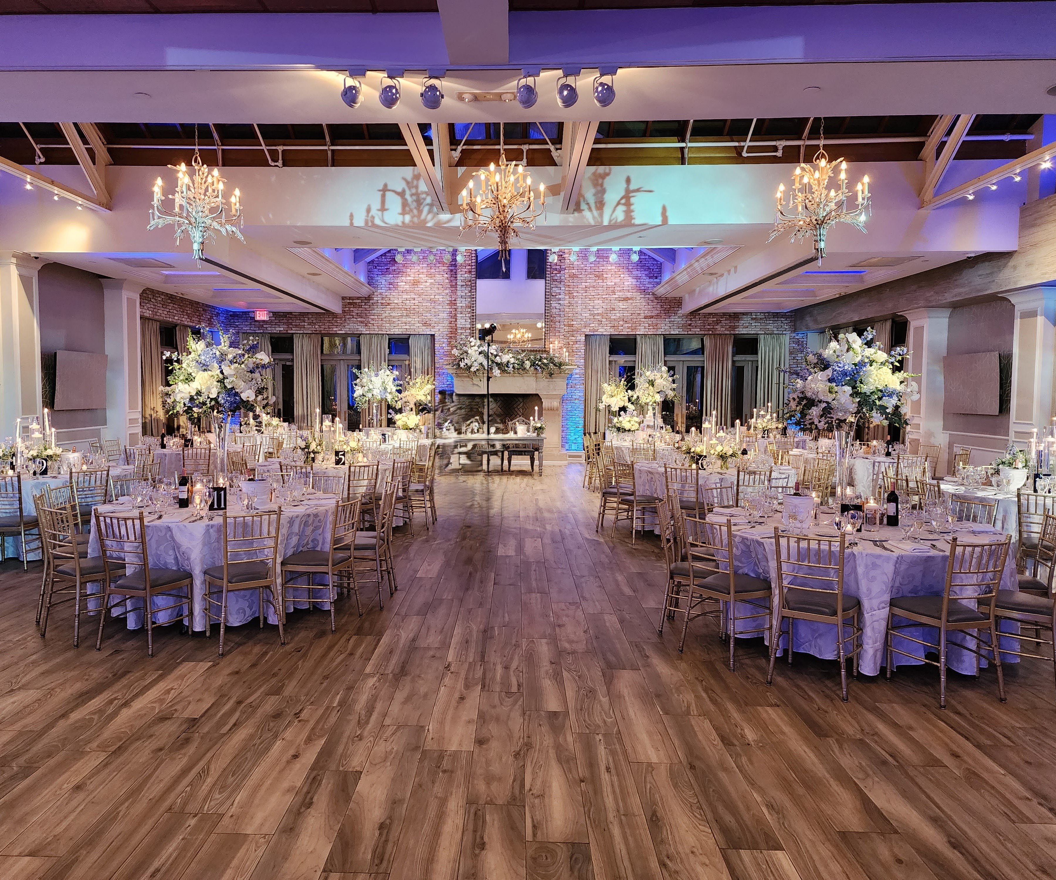 Wedding reception flowers at The Somerley at The Fox Hollow, Woodbury, NY. White and blue color palette in a variety of high and low centerpieces with candles