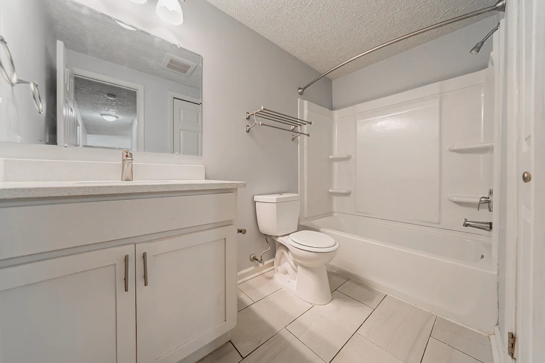 A white bathroom with a toilet, sink, and bathtub.