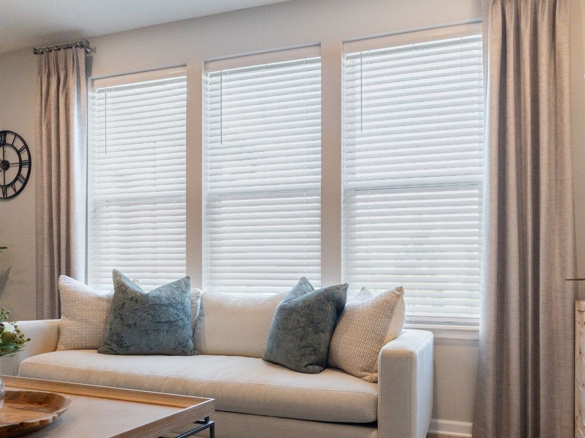 Layering wood blinds and drapery brings cozy, custom style to this living room.