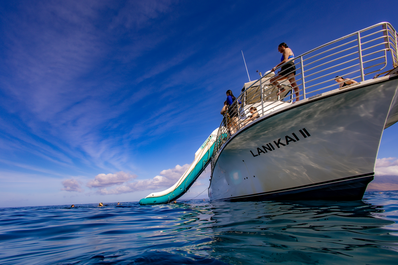 Guests prepare to use the ocean slide on the Lani Kai II during a Maui Snorkeling Tours adventure.