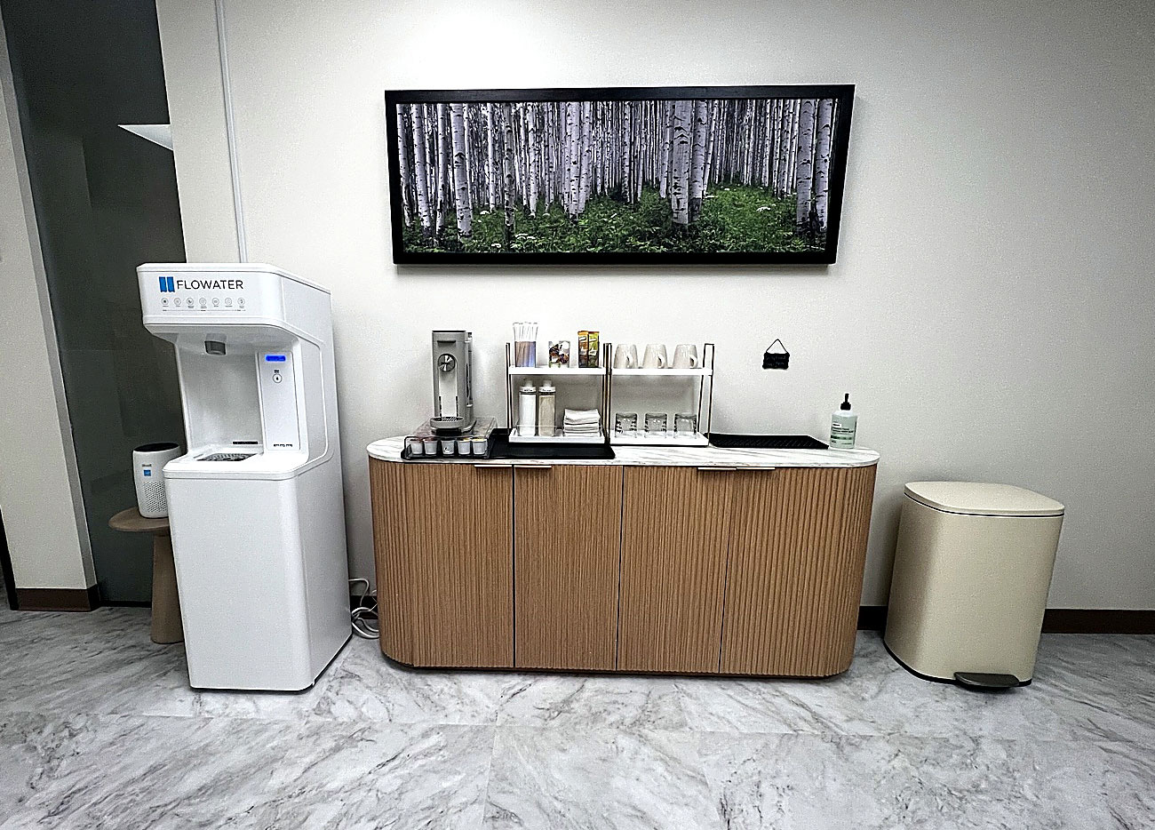 Refreshment area at Transcend Functional Health in Greenwood Village, featuring a modern beverage station, filtered water, coffee and tea amenities, and contemporary cabinetry.