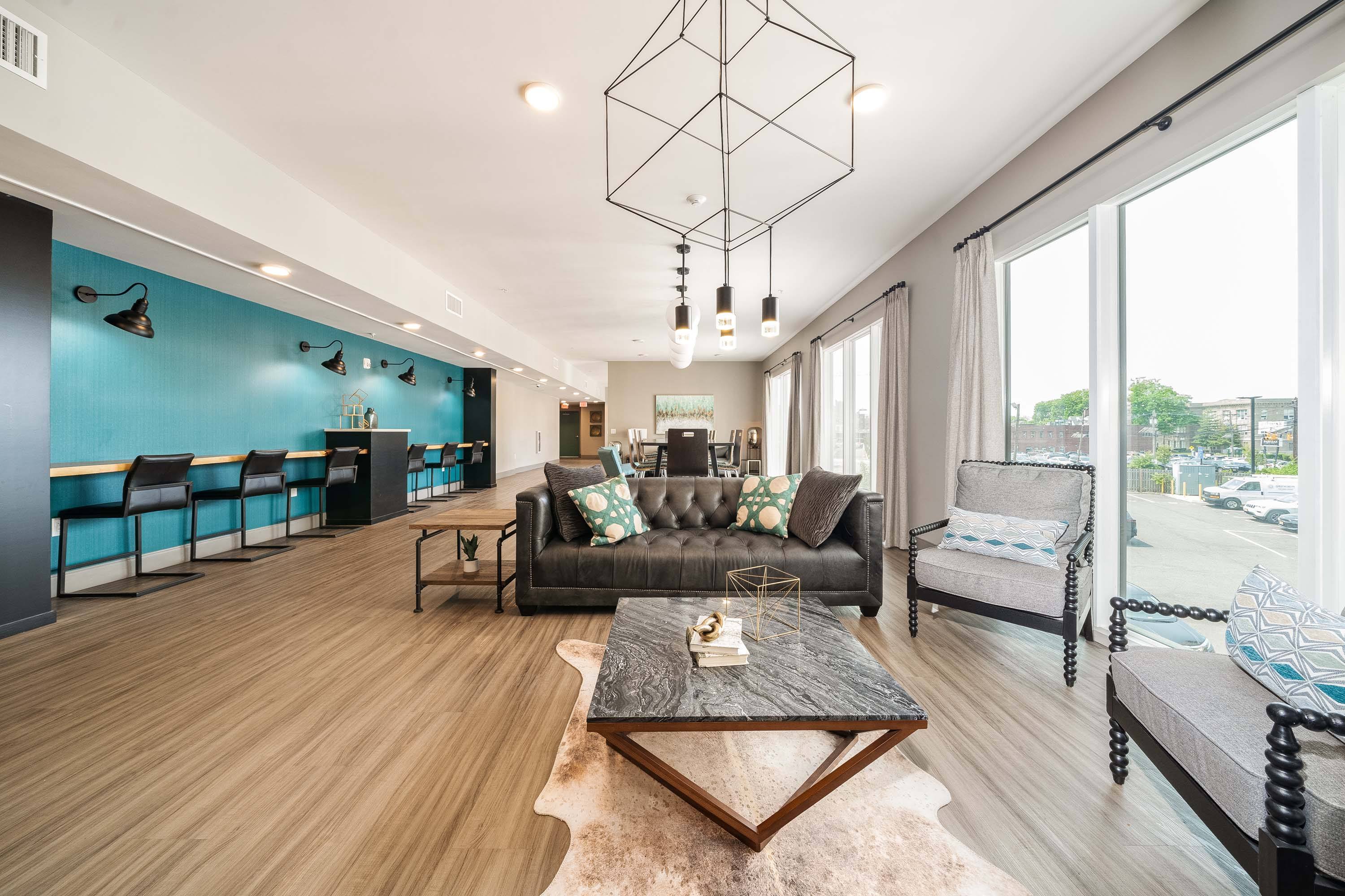 A modern living room with a black leather couch and a wooden coffee table