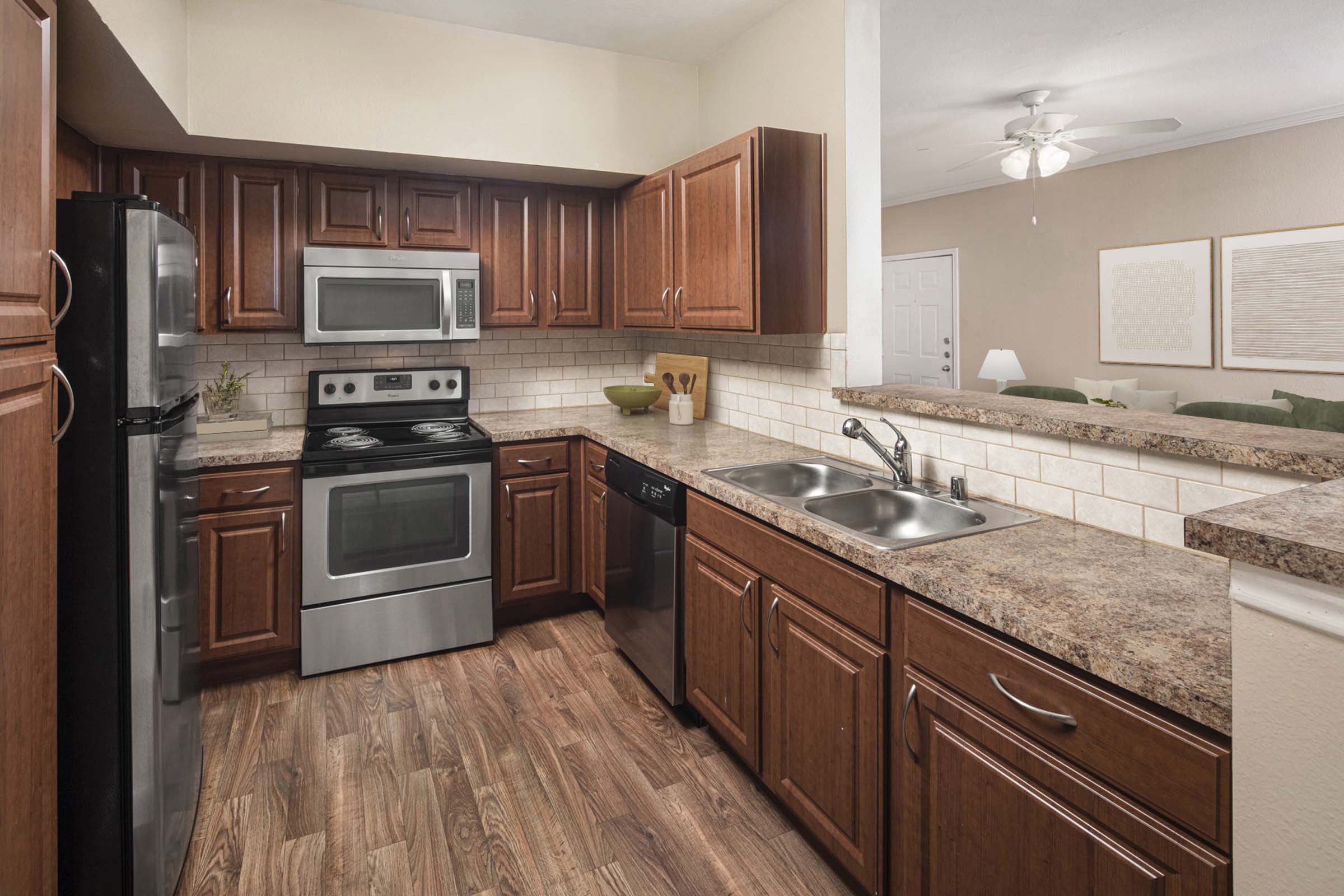 Kitchen with stainless steel appliances and bar-height countertops at Camden Buckingham apartments i 