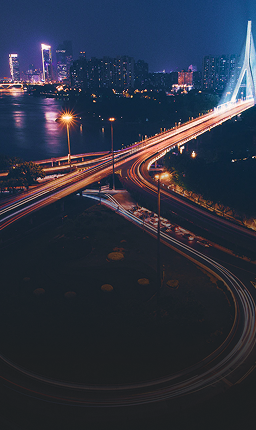 Illuminated road into the city centre at night.