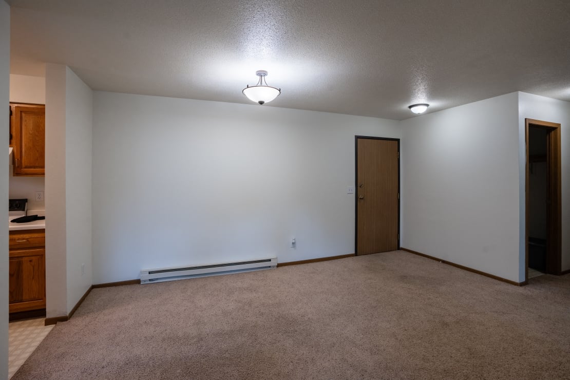 a dining room with a white wall and a door to a closet