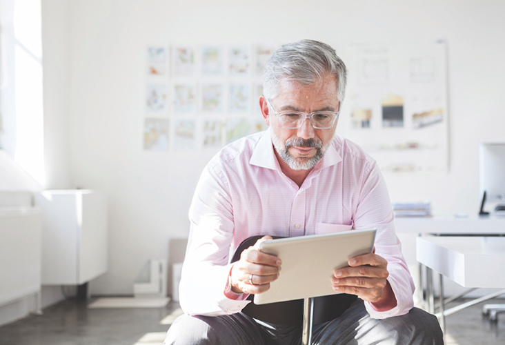 A professional reviewing documents on his iPad.