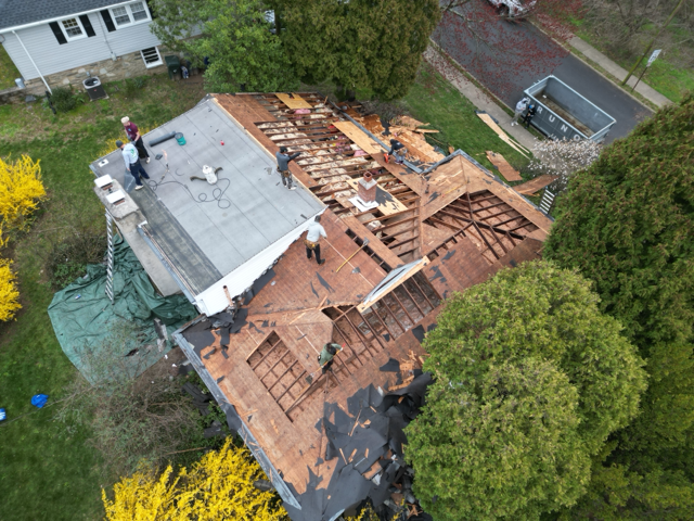 Aerial photograph capturing a major roof reconstruction project. Exposed framing and decking demonst 