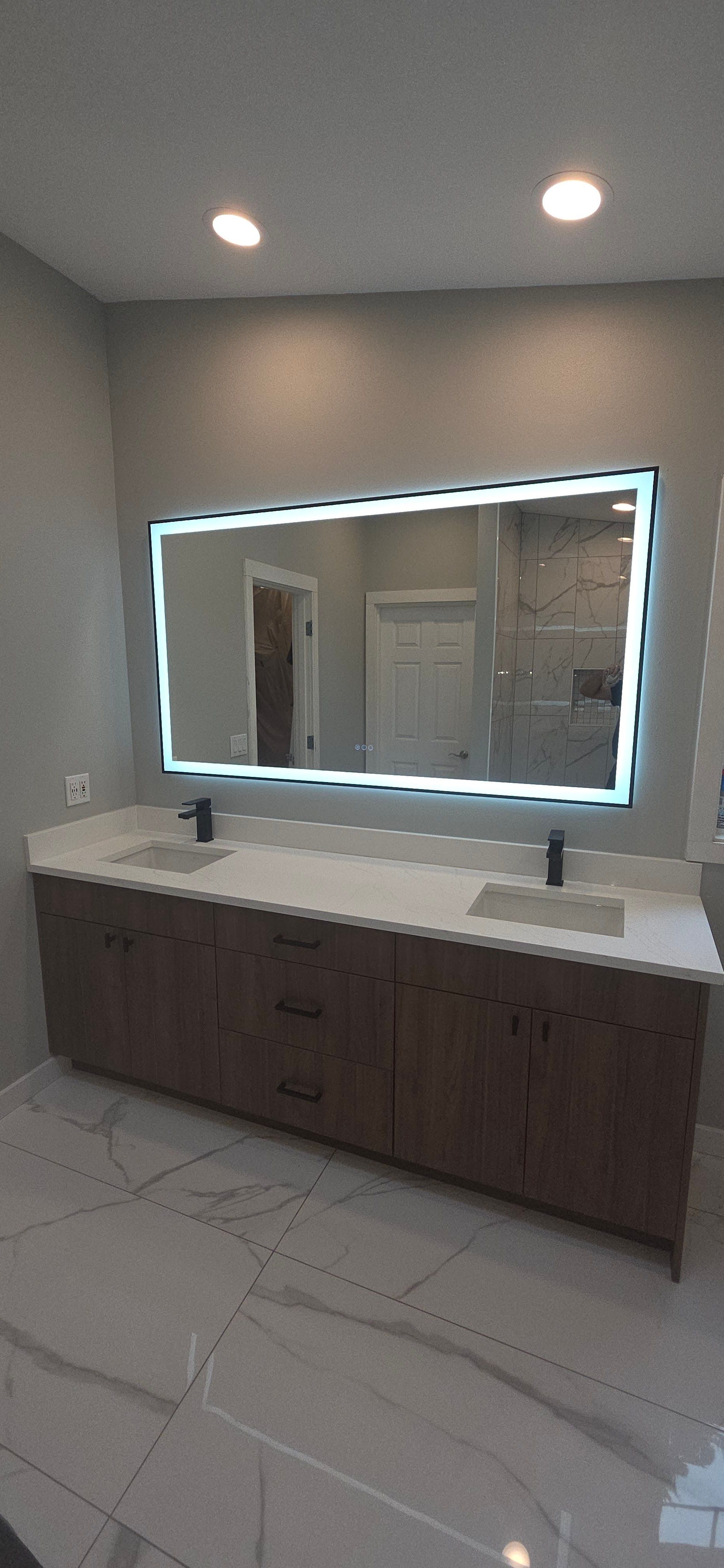 Spacious modern bathroom vanity with double sinks, quartz countertop, wooden cabinetry, black faucet 