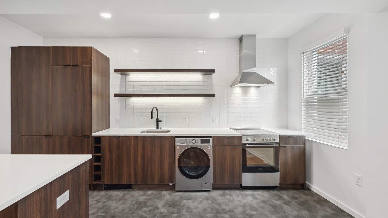 Floating shelves with under lighting and full height backsplash.