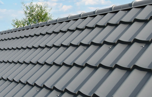 Detailed shot of dark slate grey stone-coated metal shake roofing panels, displaying interlocking we 
