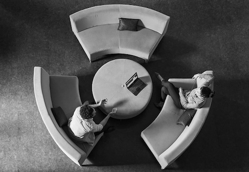 A black and white top-down shot of professionals collaborating in an office setting.