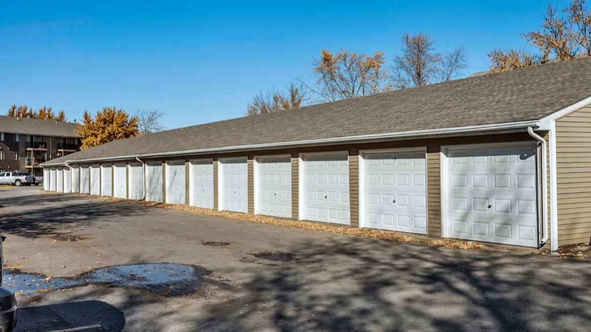 A long building with a grey roof and white garage doors