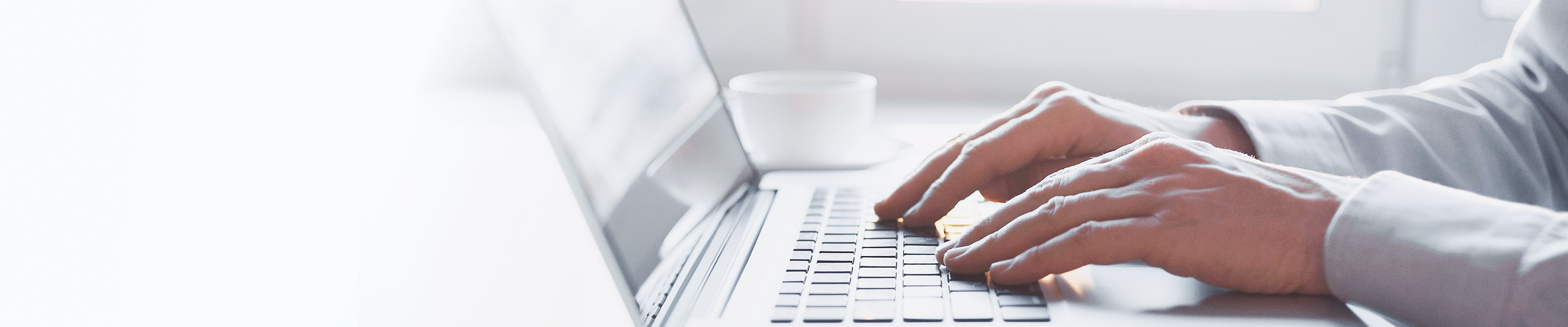 Close-up of a person typing on their laptop.