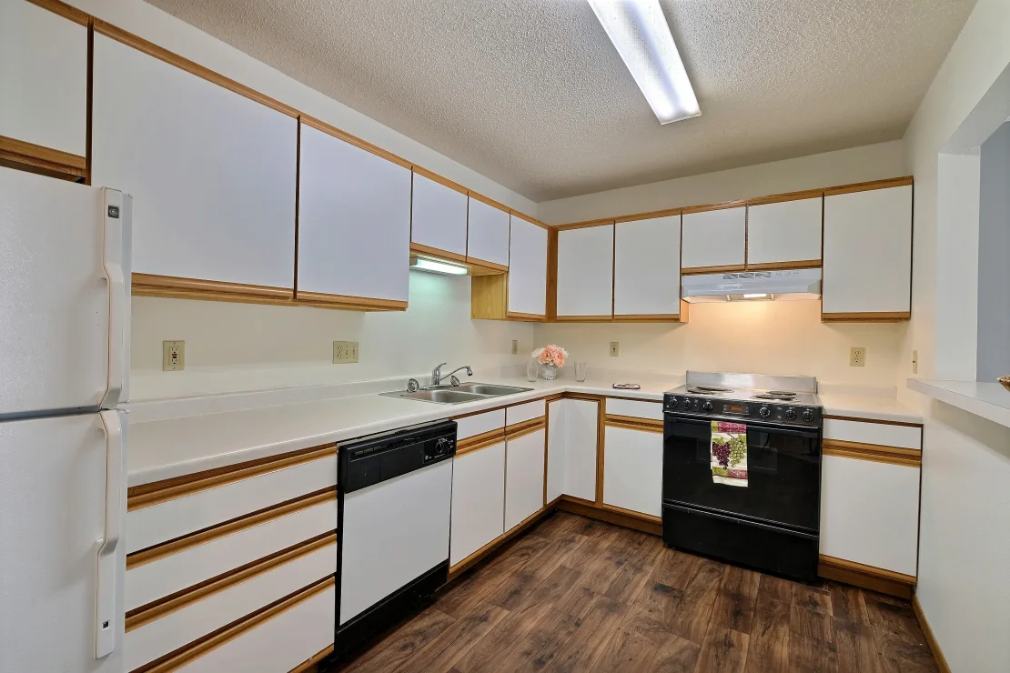 a kitchen with white cabinets and black appliances