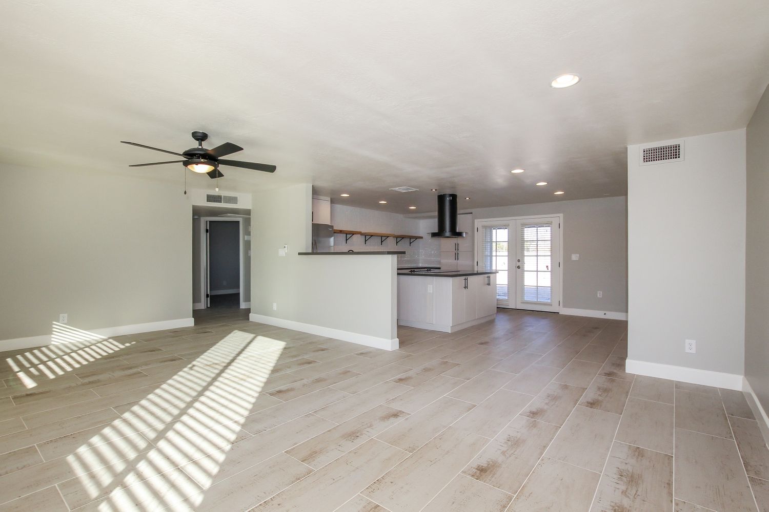 Spacious family room with easy access to the modern kitchen at Invitation Homes Phoenix.