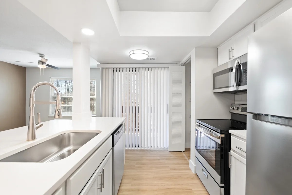 A modern kitchen with white cabinets and stainless steel appliances.