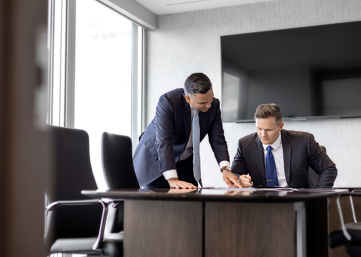 Ahsen Ansari and Trevor Hodgins collaborating in a board room.