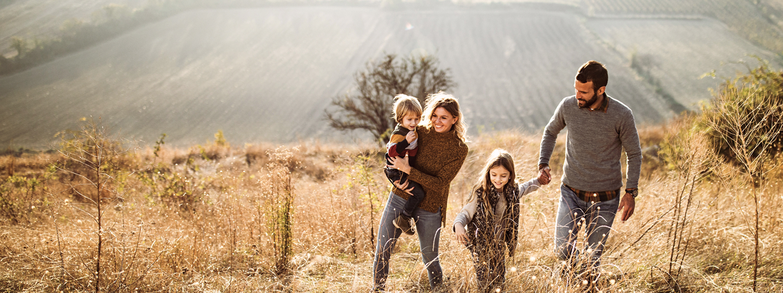 A young family enjoying a hike on a sunny day.