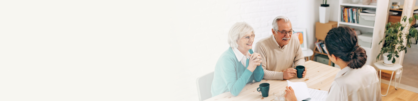Senior clients speaking with an advisor across a table.