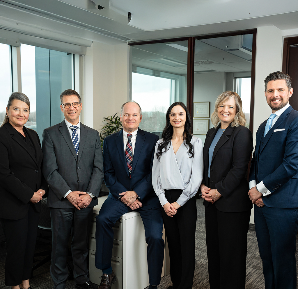 Team Adam standing side by side in their office.