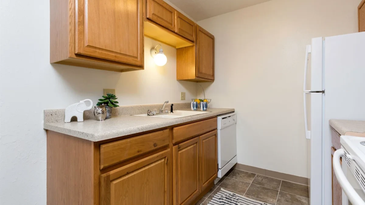A kitchen with wooden cabinets and a white fridge