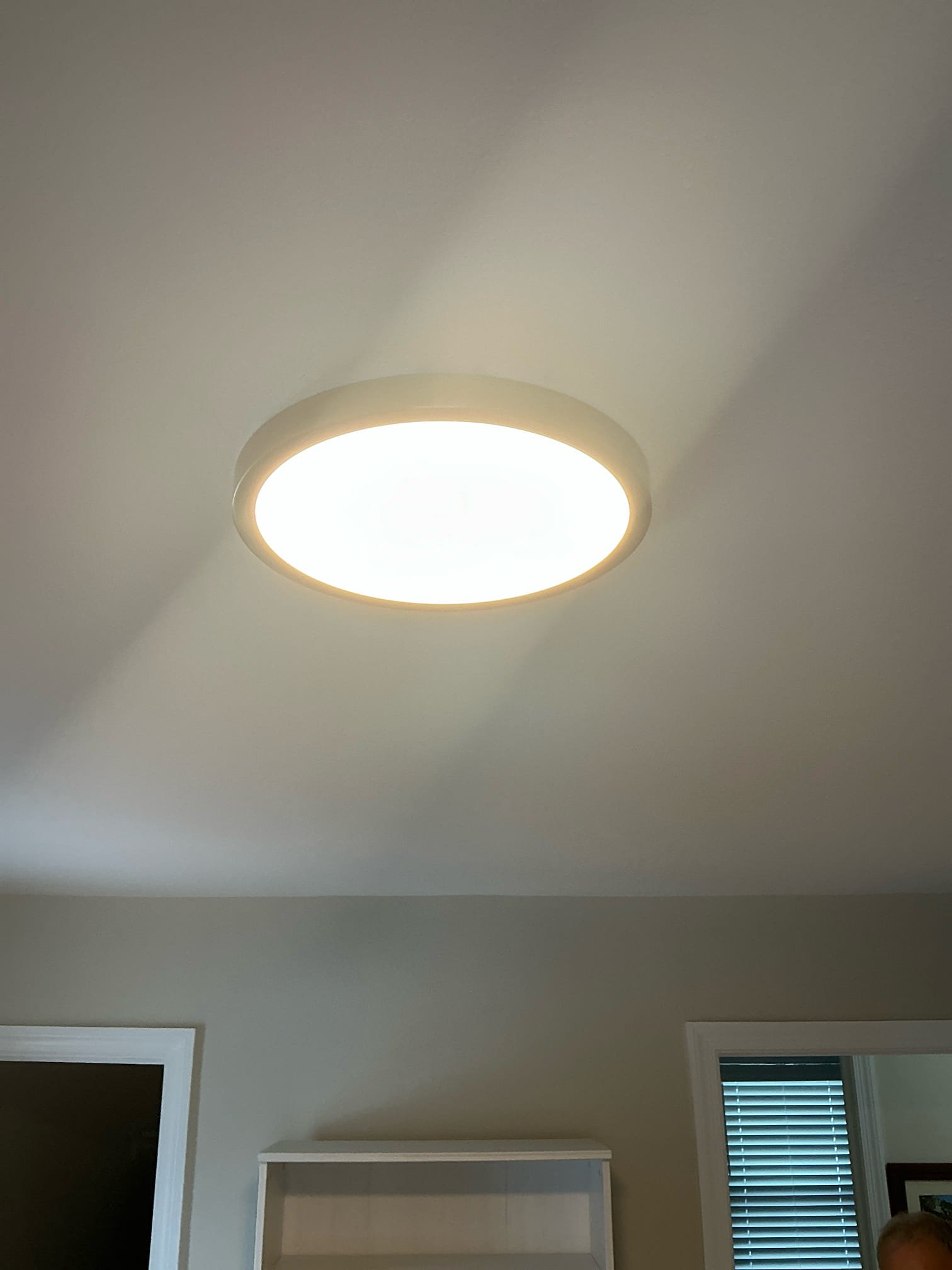 A modern flush-mount LED ceiling light installed by Thomas Edison Electric on a vaulted ceiling in a Bryn Mawr, PA home. The slim-profile fixture provides even, warm illumination throughout the room.