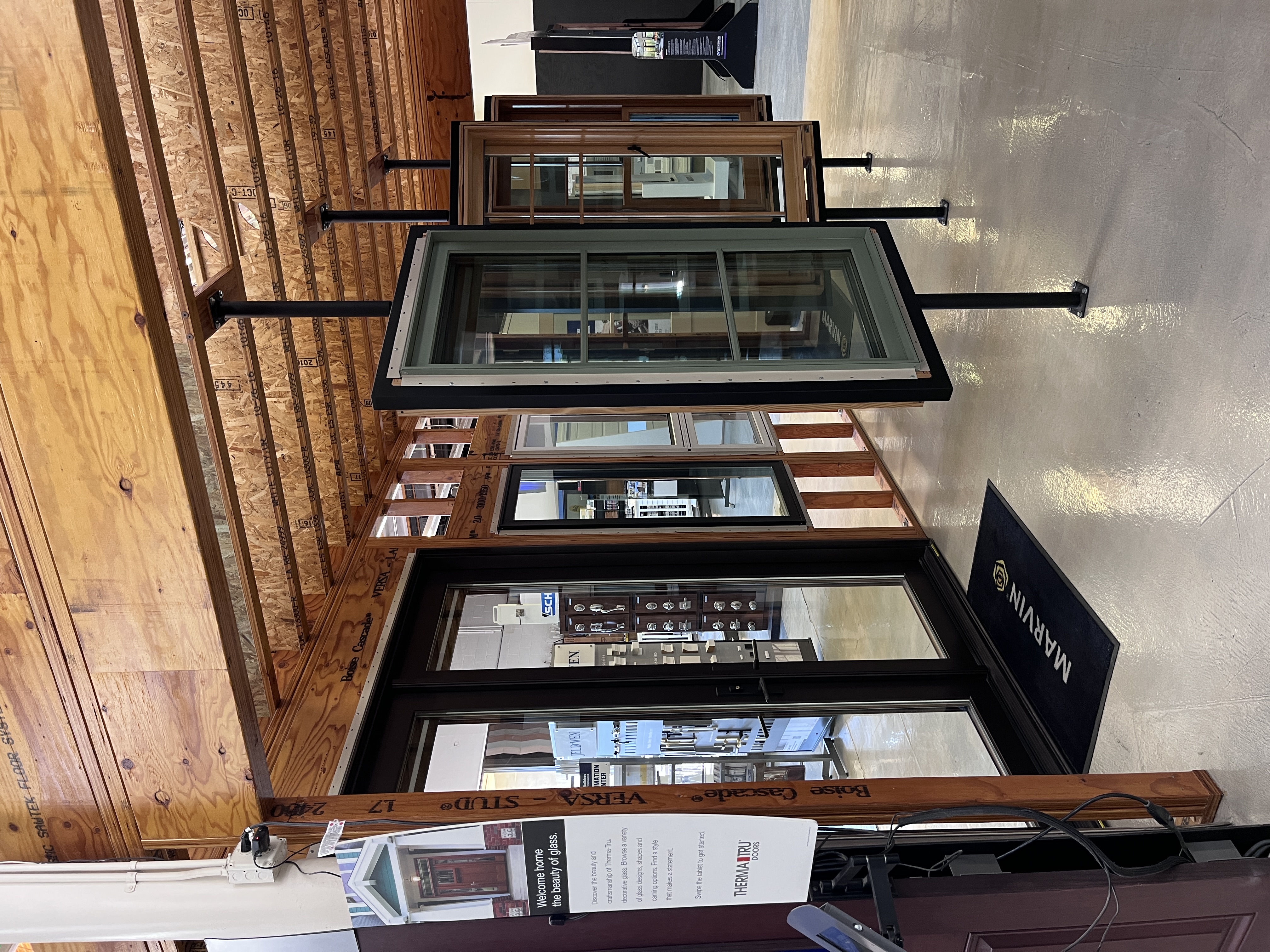 Marvin and JELD-WEN window and door showroom section at Builders FirstSource Thousand Oaks, CA, featuring a black French door display and rotating window samples.
