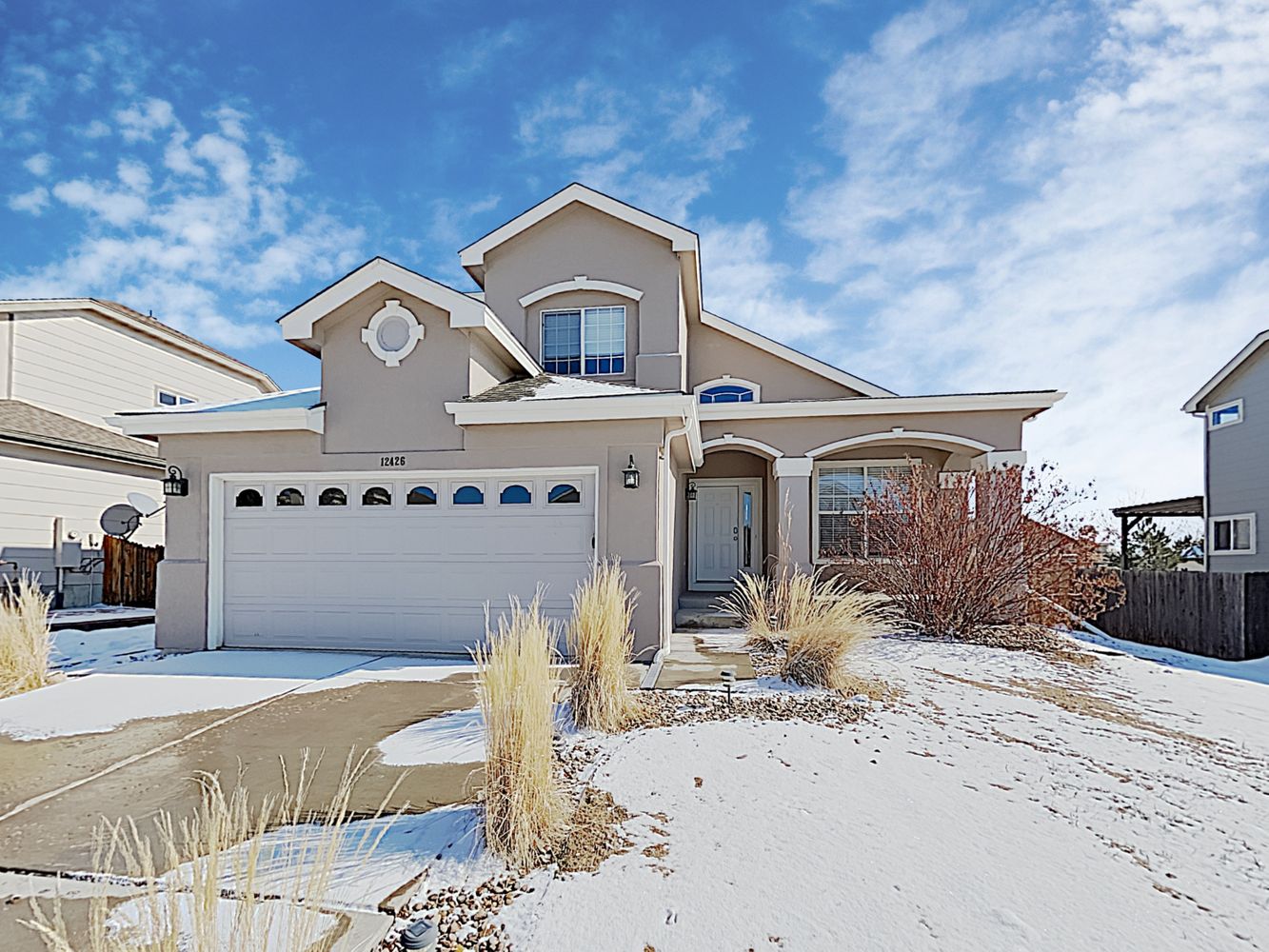 Modern home with covered porch and two-car garage at Invitation Homes Denver.