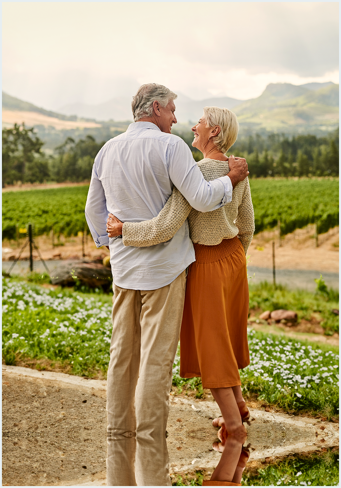 Un couple d’aînés s’enlace dehors.