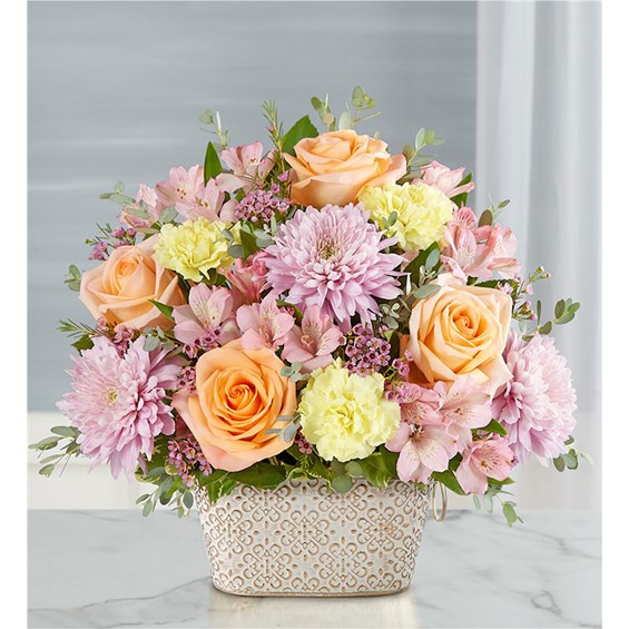 Celebrate the life of a loved one with our beautiful floral tribute. A mix of blooms in soothing pastel shades is a symbol of enduring love. Designed in our Remembrance Cachepot, featuring an embossed pattern and finished with a gold brushed ivory surface.