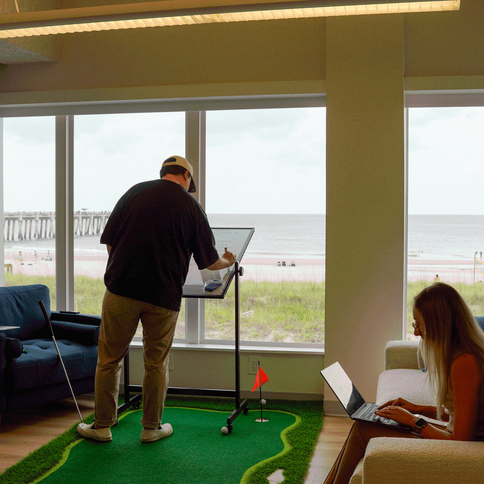 White board brainstorm with marketing manger and graphic designer overlooking beach