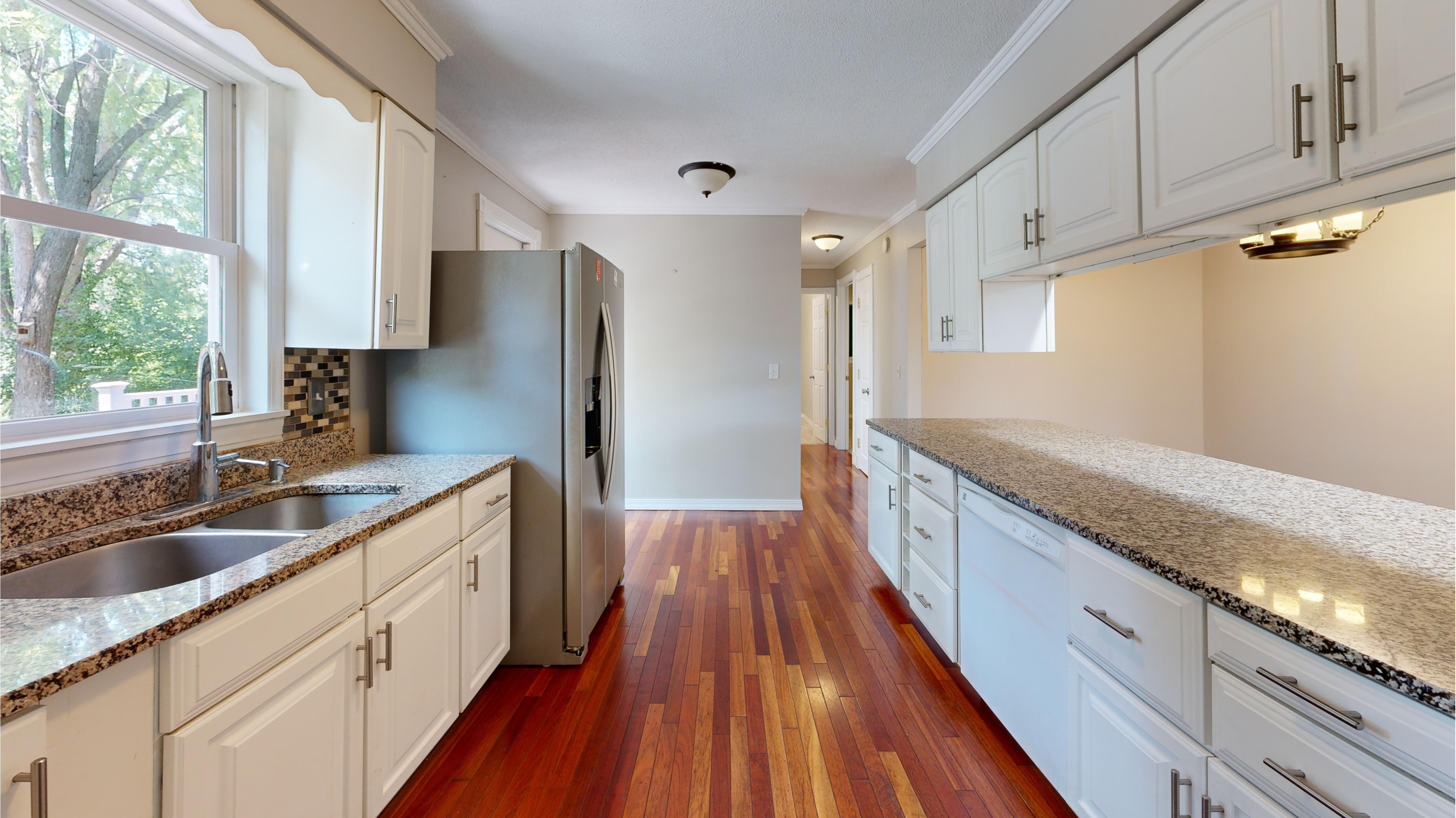 Bright kitchen featuring freshly finished white cabinetry that creates a cleaner, more modern appearance. This image represents Crest & Crown LLC’s professional cabinet painting services for kitchens and residential interiors.