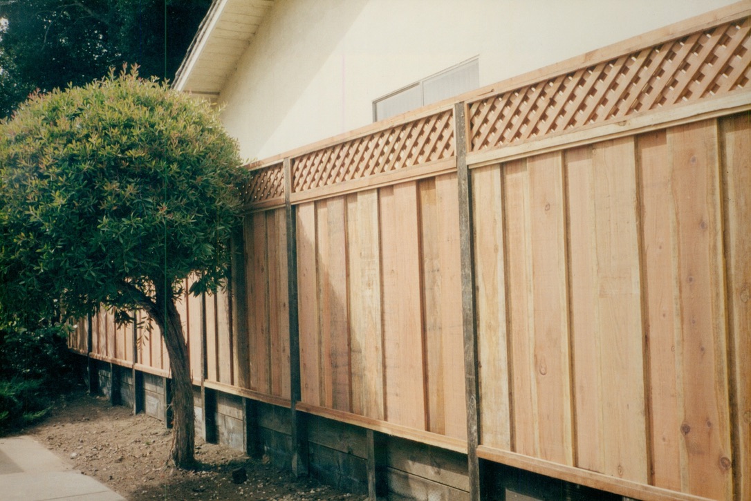 Wood privacy fence with lattice top detail installed along a residential property line.